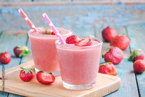 Two glasses of strawberry smoothie with straws