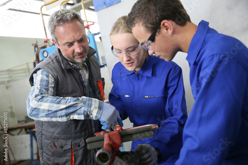 Students in plumbing listening to teacher's instructions