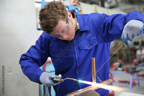 Foto student in plumbing professional training, working on copper
