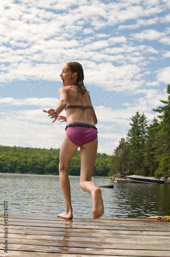 Bilde på lerret tween girl jumping off a dock into a lake