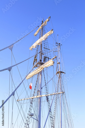 Obraz na plátne Sailing ship mast against a clear blue sky.