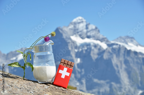 Swiss chocolate and jug of milk against mountain peak. Switzerla photo