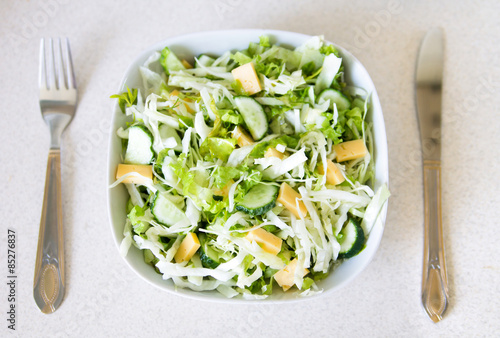 Fresh spring salad made of cucumbers, cabbage, cheese and lettuce.