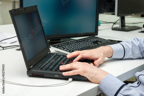 Man's hands typing on laptop. Internet surfing. Programming code