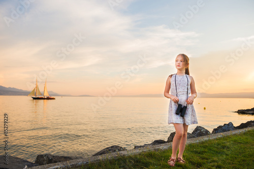 Outdoor portrait of a cute little girl playing by the lake on a nice warm evening © annanahabed