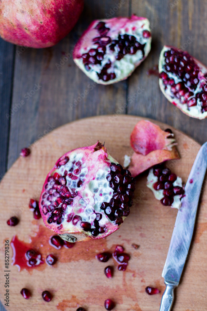 organic pomegranate open cut in half and full one on a wooden dark table background decorated in rustic style organic pomegranate open cut in half and full one on a wooden dark table background decorated in rustic style