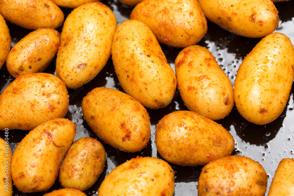 Shiny fresh, oiled potatoes on an oven plate Shiny fresh, oiled potatoes on an oven plate