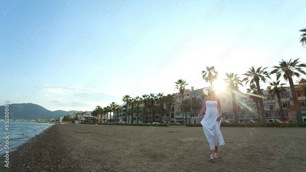 Woman in white dress and hat on the beach. RAW video record. Stock ...
