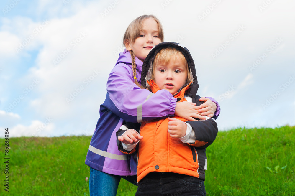 Outdoor portrait of two cute kids wearing warm coats Outdoor portrait of two cute kids wearing warm coats