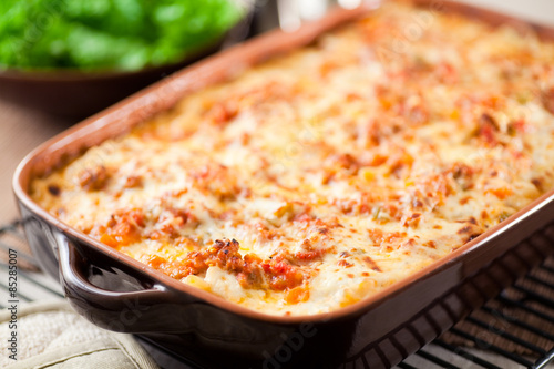 Homemade baked Lasagna in casserole dish. Layered with long simmered ragu, béchamel sauce, noodles and quality parmesan cheese. 