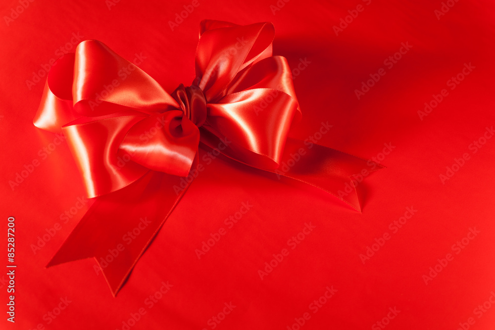 Red Silk Christmas Bow on red background with copy space. Red Silk Christmas Bow on red background with copy space.