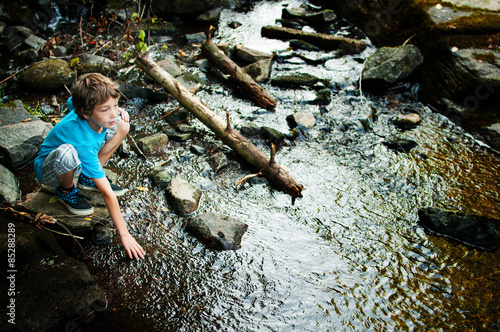 Foto little boy playing in a creak