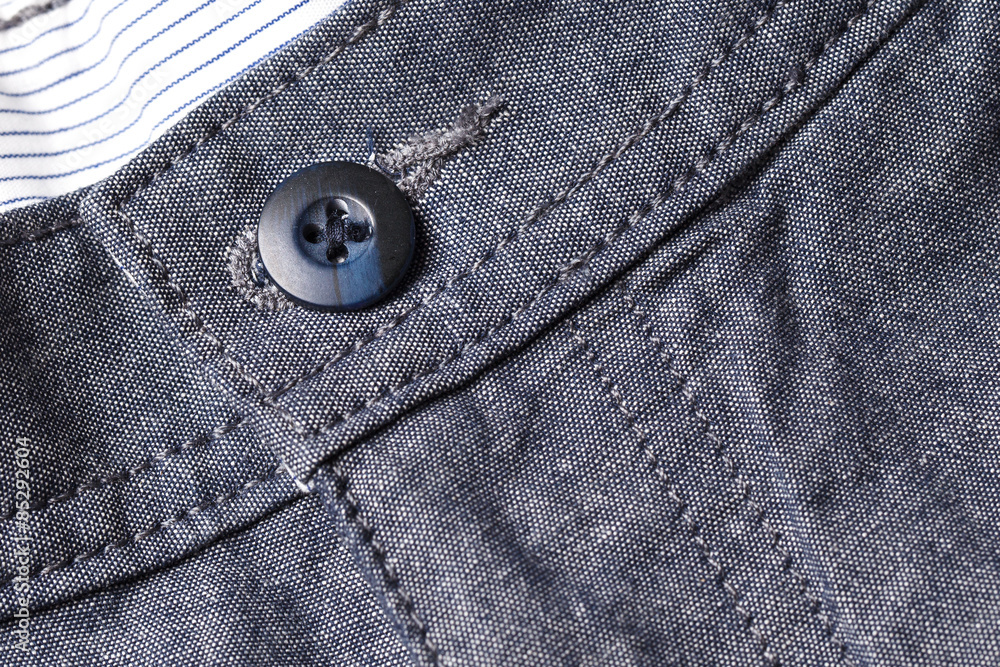 Black button pocket on gray color pants background. Black button pocket on gray color pants background.