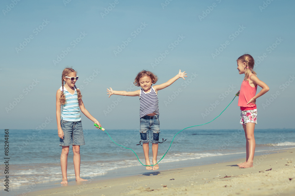 two sisters and brother playing on the beach
