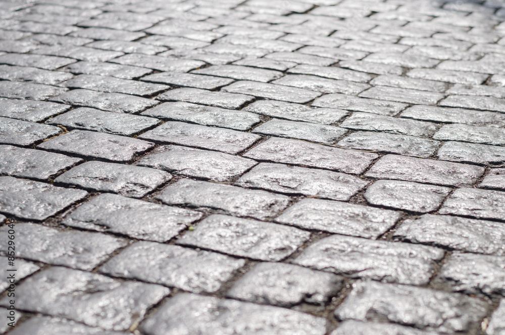 Abstract background of old cobblestone pavement under sunlight