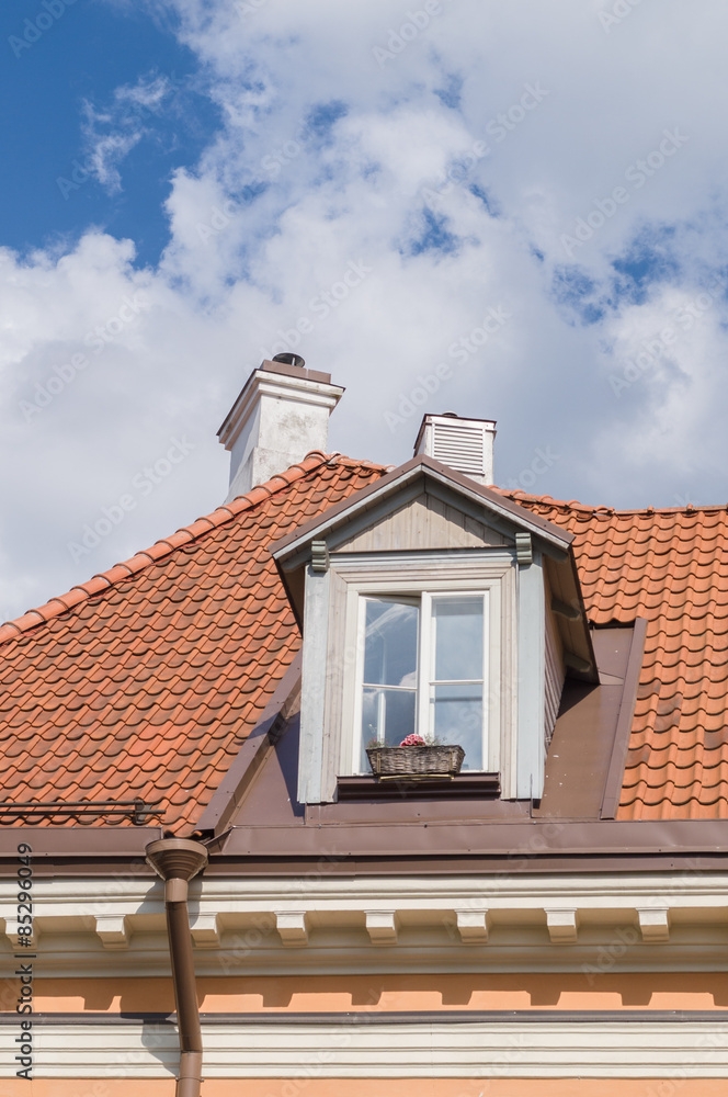 Authentic mansard window in a old style tiled roof