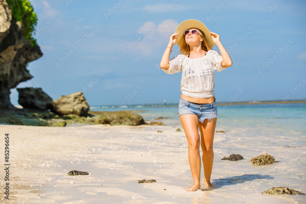 Young skinny caucasian girl at the beach with blue sky on Young skinny caucasian girl at the beach with blue sky on