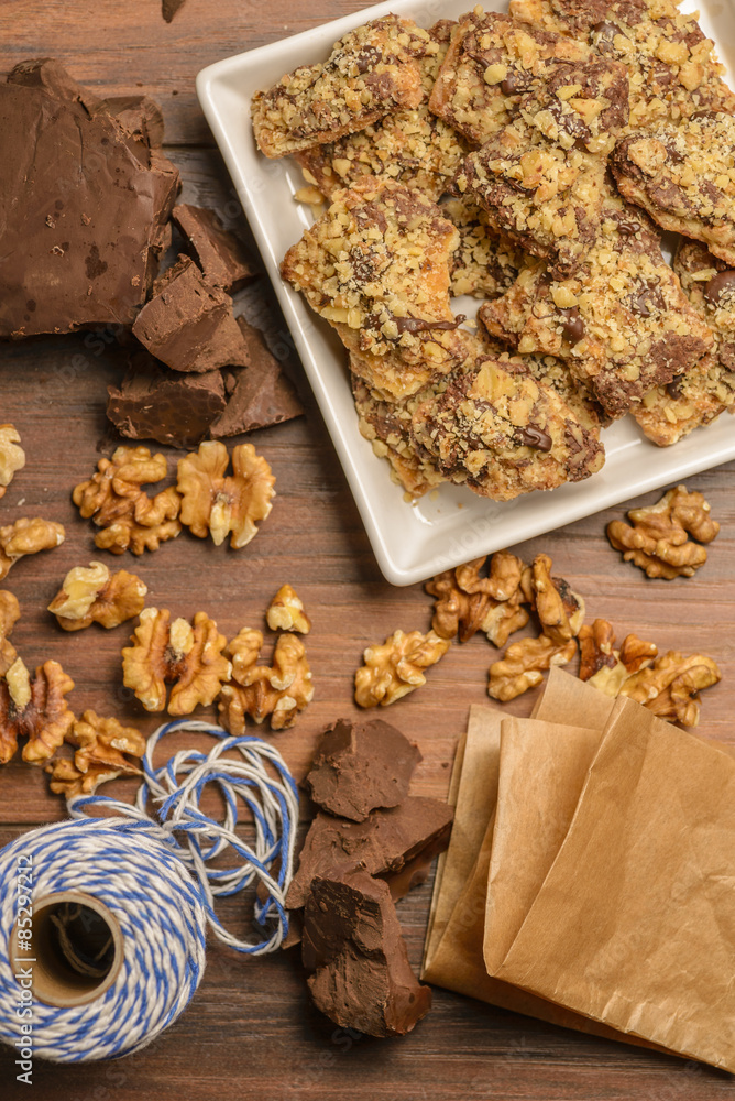 Fototapeta premium Overhead view of homemade chocolate walnut cookies with ingredients and gift wrap supplies.