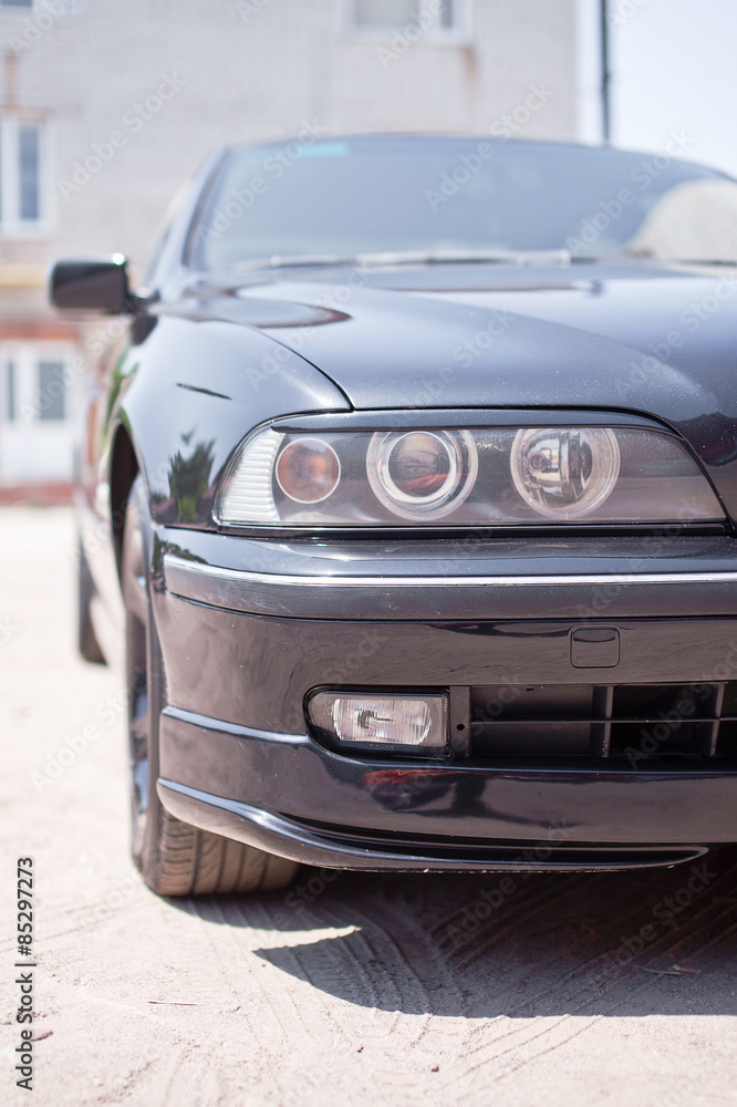 Obraz premium Closeup photo of black car's headlight