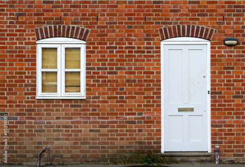 White door and window on brick wall background.