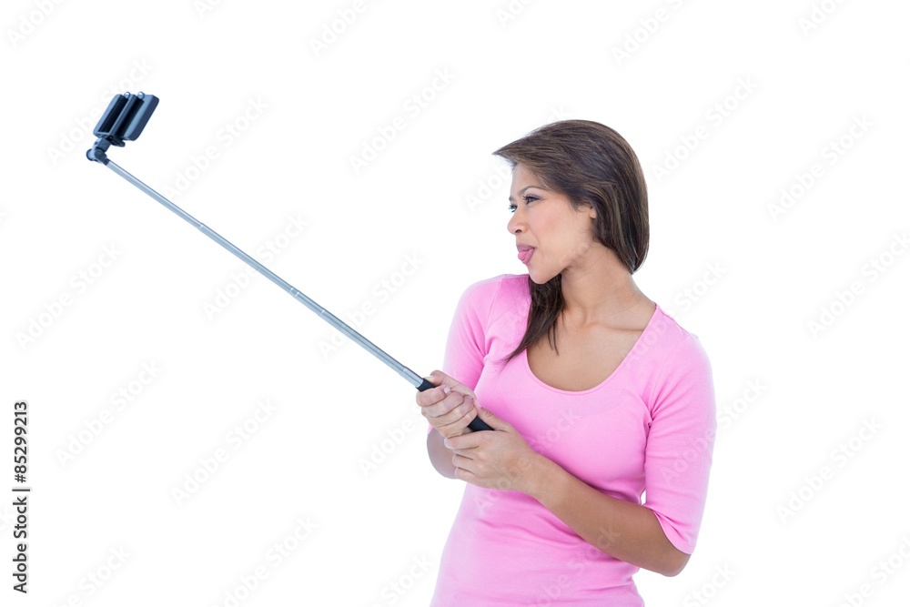 Pretty brunette using a selfie stick Pretty brunette using a selfie stick