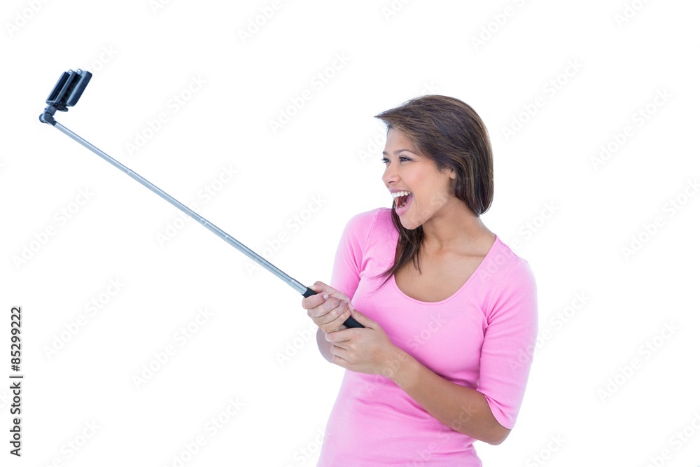 Pretty brunette using a selfie stick Pretty brunette using a selfie stick
