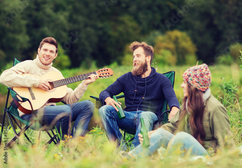 group of tourists playing guitar in camping