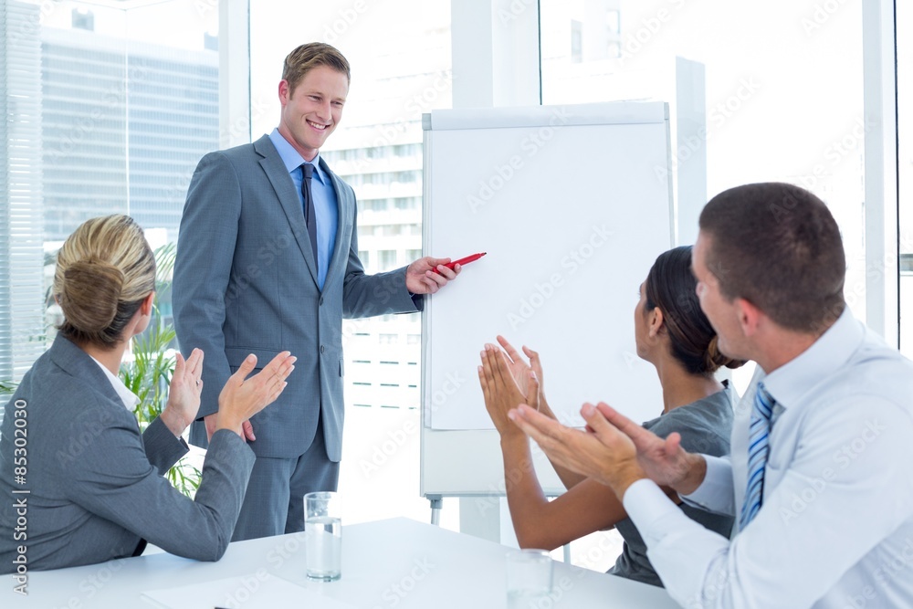 Manager presenting whiteboard to his colleagues Manager presenting whiteboard to his colleagues