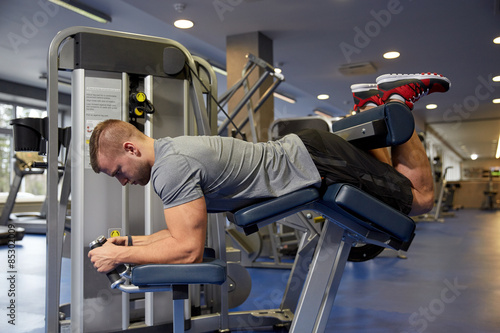 man flexing leg muscles on gym machine