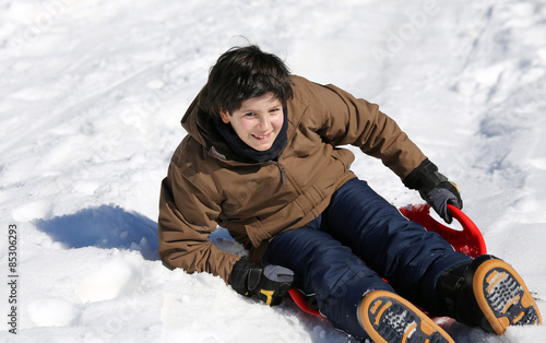 child enjoying sledding on snow in the mountains in winter photo