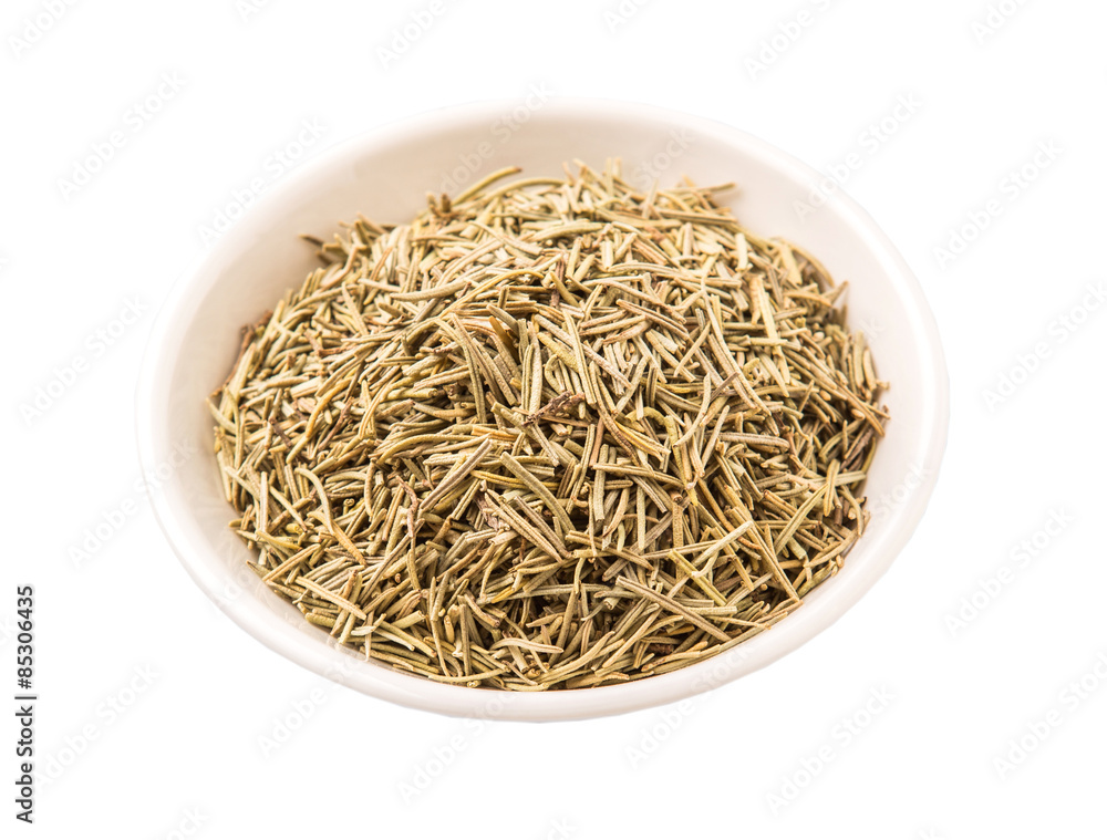 Dried rosemary herb leaves in white bowl white background