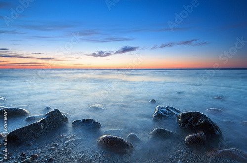 Sunset over the Baltic sea. The pebbly beach in Rozewie