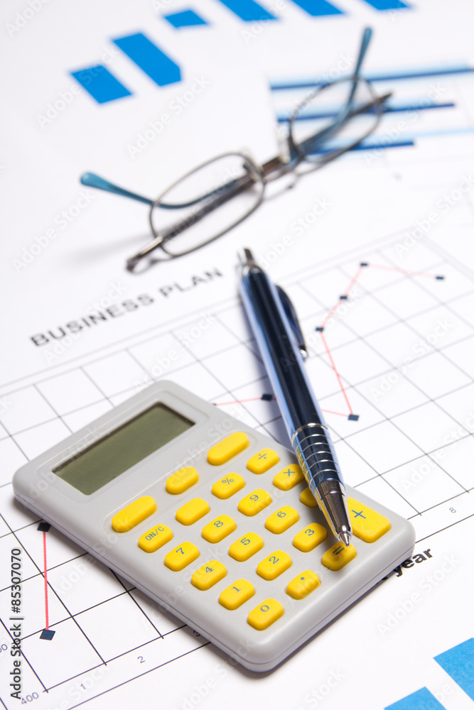 business concept - graphs, charts, pen, glasses and calculator business concept - graphs, charts, pen, glasses and calculator