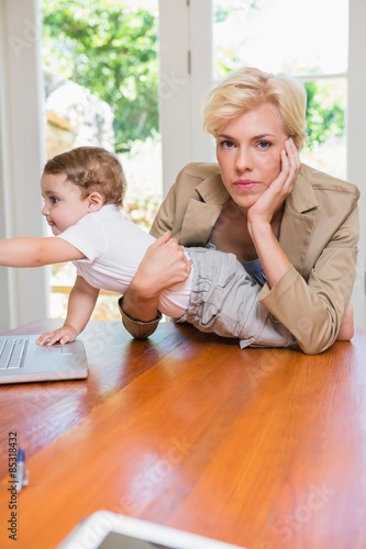 Blonde woman with his son using laptop