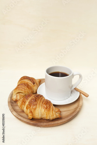 Golden brown croissant and black coffee