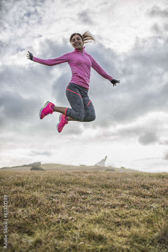 Spain, Gijon, sportive young woman jumping on meadow Spain, Gijon, sportive young woman jumping on meadow