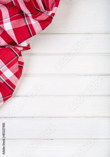 Top view of checkered kitchen towels on wooden table. 
