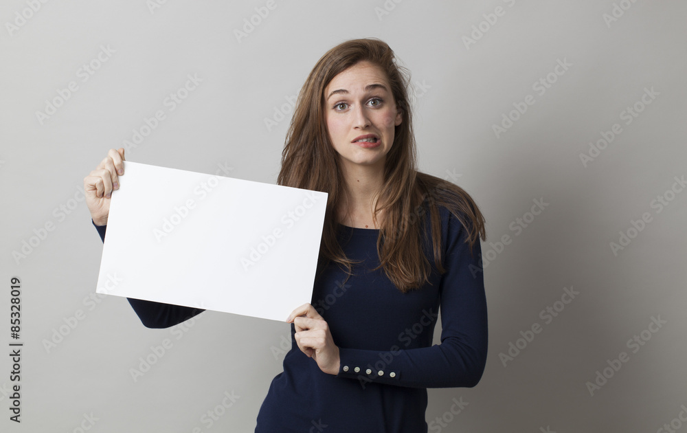Naklejka premium stunned young woman biting her lips in holding a scary news on a blank banner