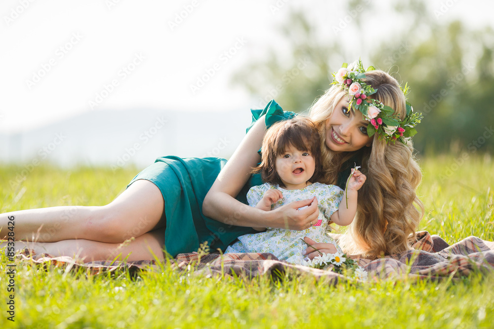 Fototapeta premium Happy woman with a child resting on the nature