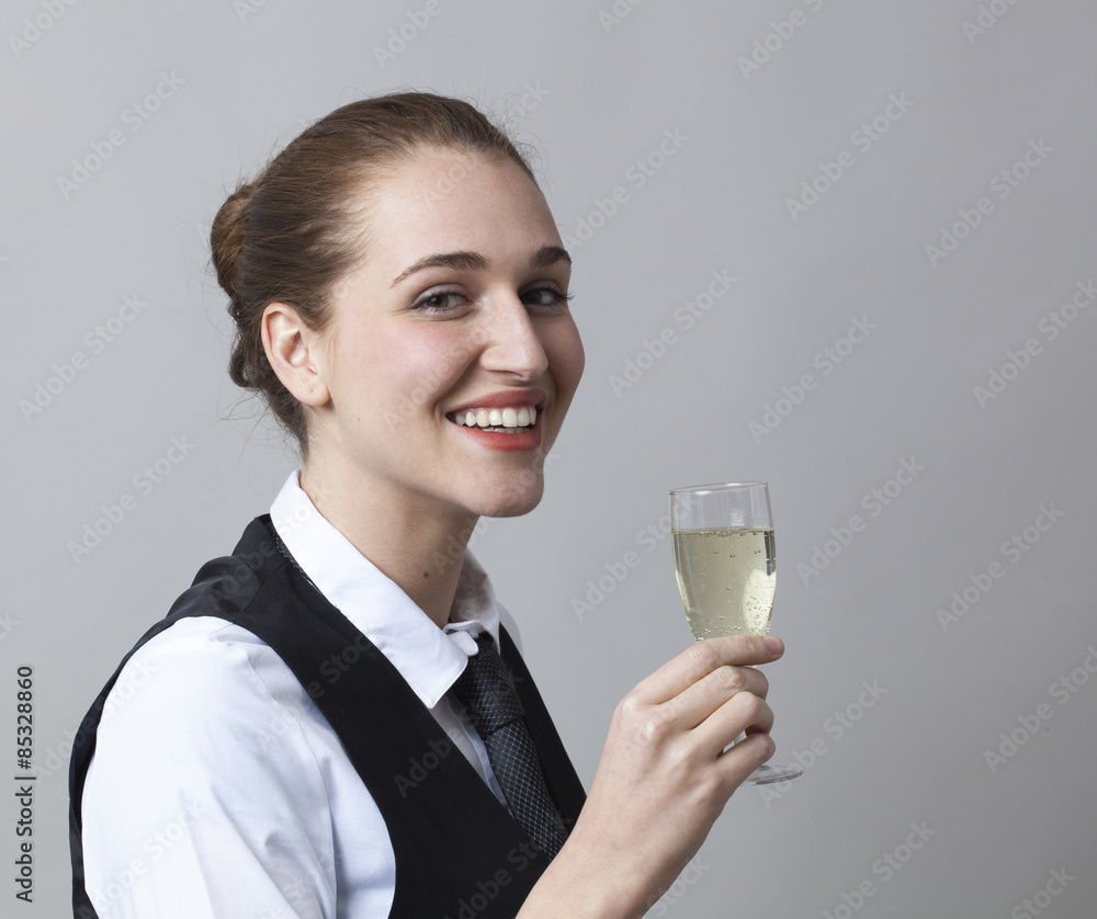 Beautiful young woman wearing uniform of wine waitress happy to raise Champagne glass, profile view Beautiful young woman wearing uniform of wine waitress happy to raise Champagne glass, profile view