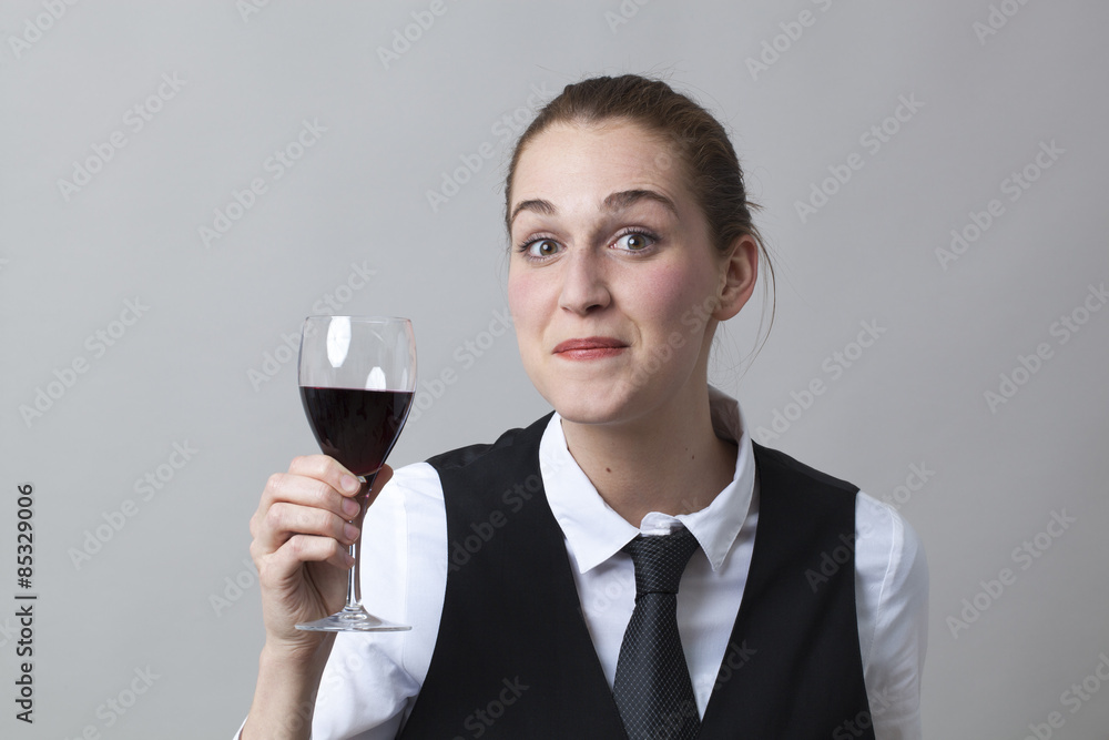 Beautiful young woman wearing uniform of wine waitress delighted by taste of red wine
