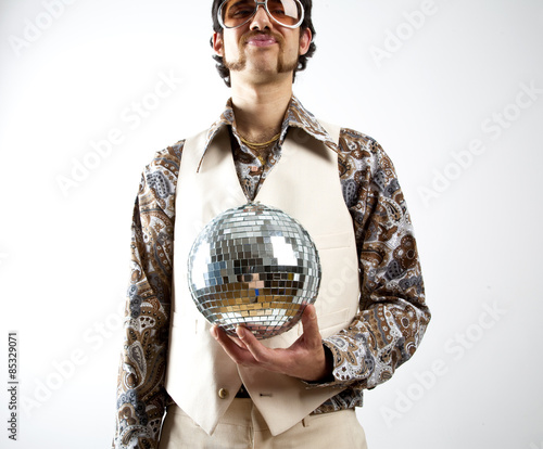 Foto Portrait of a retro man in a 1970s leisure suit and sunglasses holding a disco b