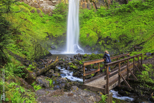 USA, Oregon, Multnomah County, Columbia River Gorge, Elowah Falls, Female tourist standing on bridge photo