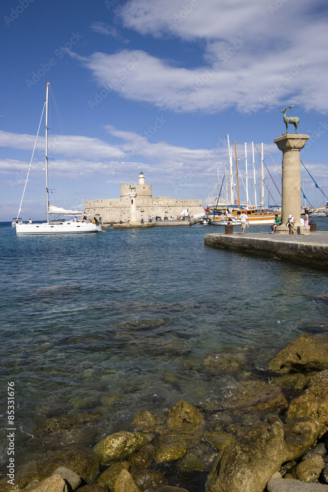 Mandraki harbor with castle and famous deer statues at the island of Rhodes, Greece