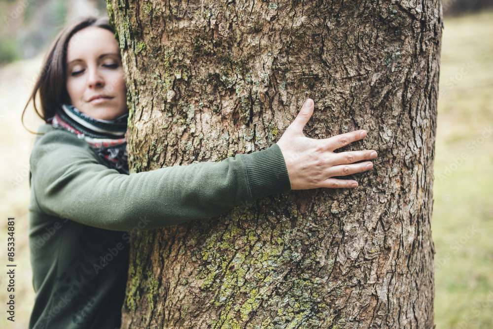 Woman hugging a big tree trunk Woman hugging a big tree trunk