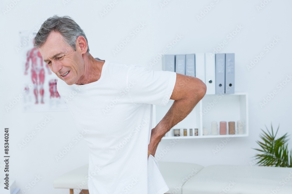 Suffering patient touching his back 