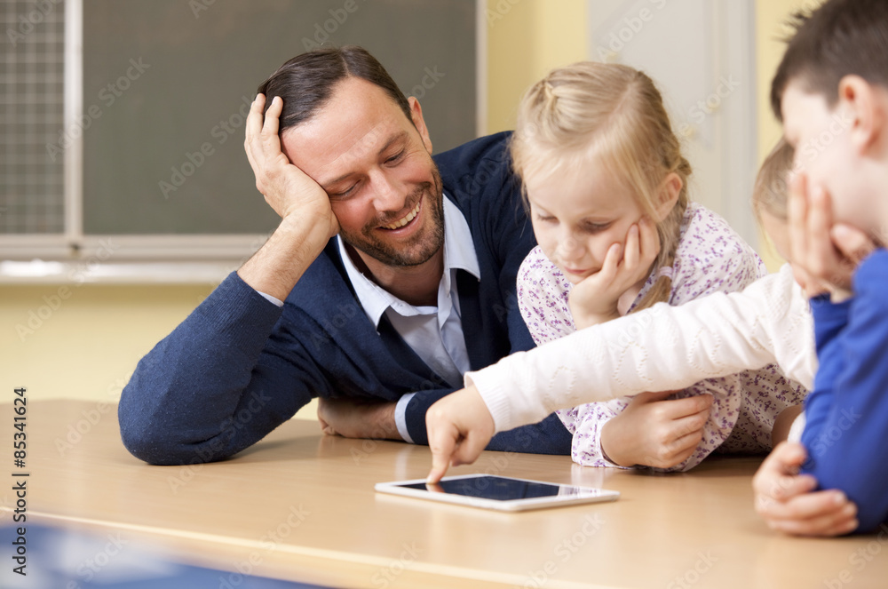 Teacher with pupils using digital tablet in classroom Teacher with pupils using digital tablet in classroom