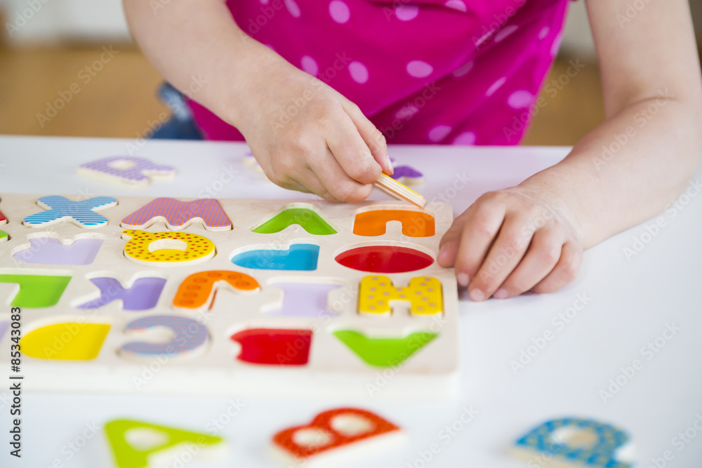 Little girl learning alphabet with wooden letters Little girl learning alphabet with wooden letters