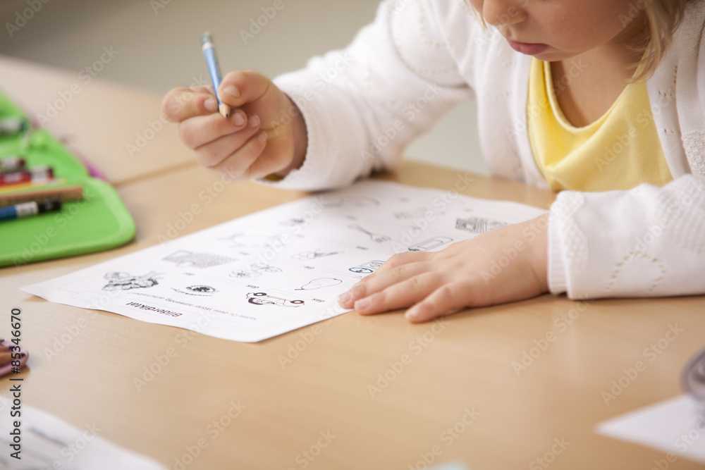 Schoolgirl working on work sheet in classroom Schoolgirl working on work sheet in classroom