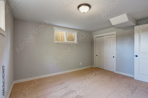 Carpeted bedroom with windows and a closet.